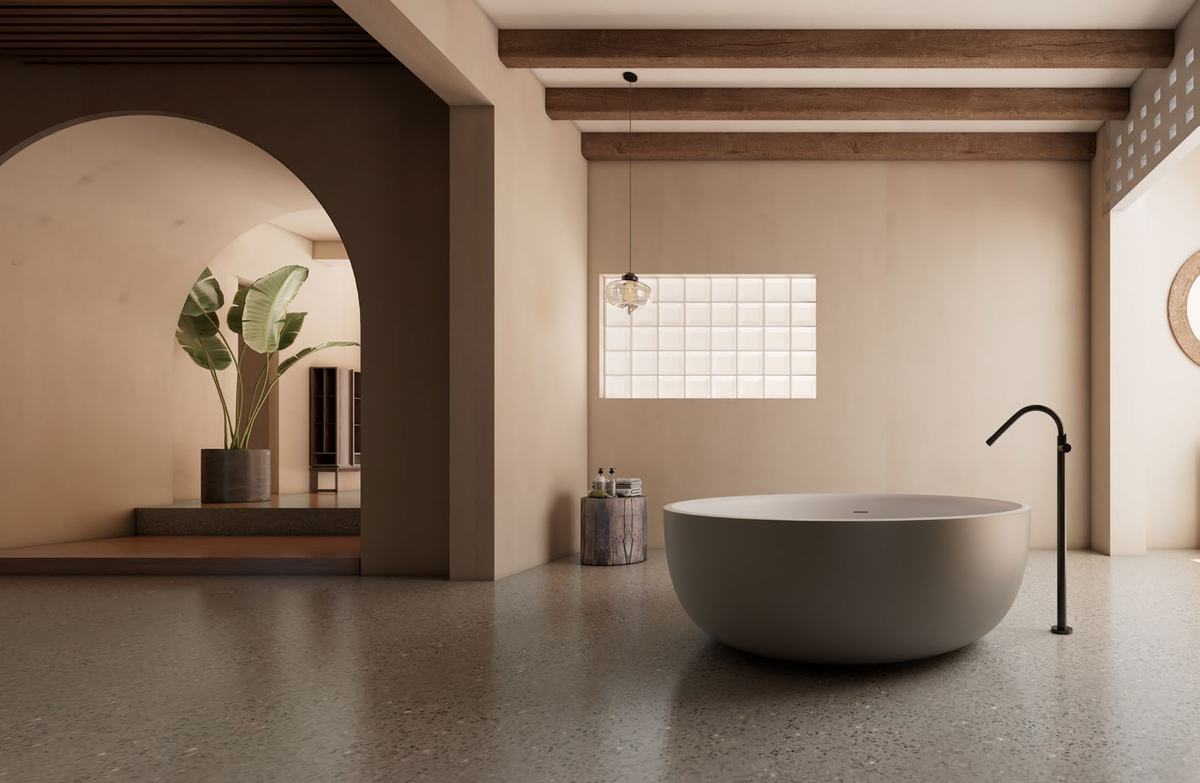 Stone-toned freestanding bath under an arched opening