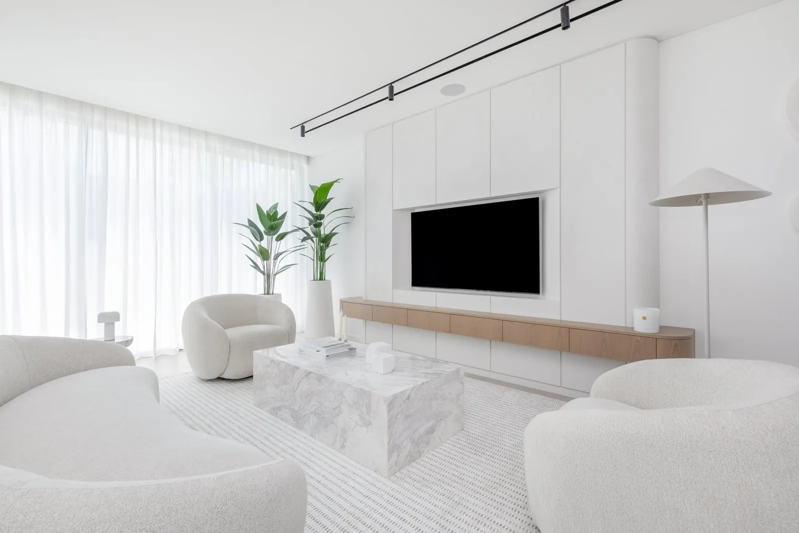 Meadows villa living room with pale seating, timber joinery and sheer curtains