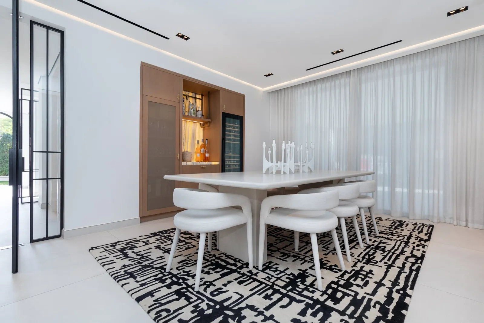 Mirador villa dining room with upholstered chairs and full-height curtains